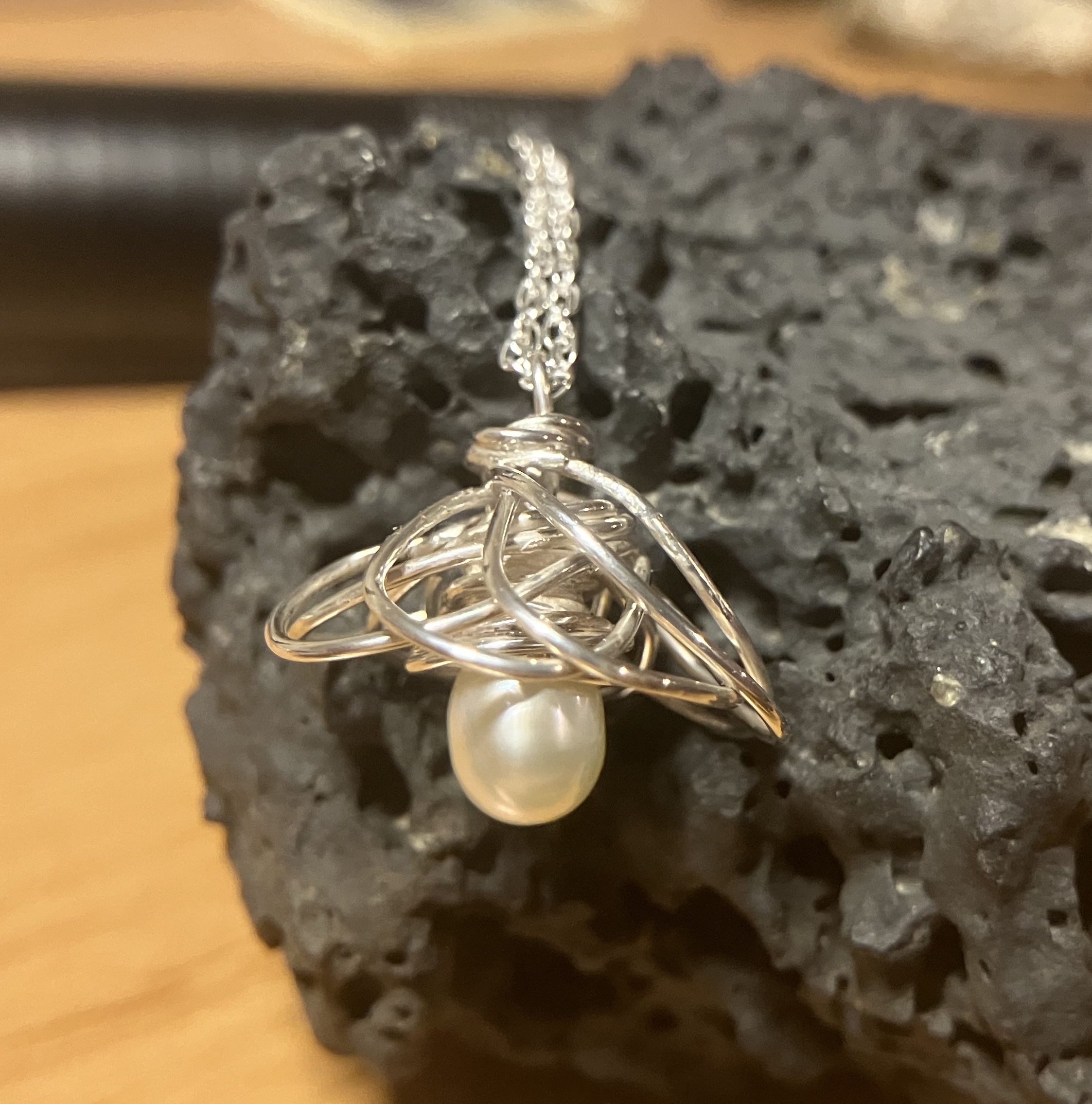 A flower made from twisted wire around a pearl