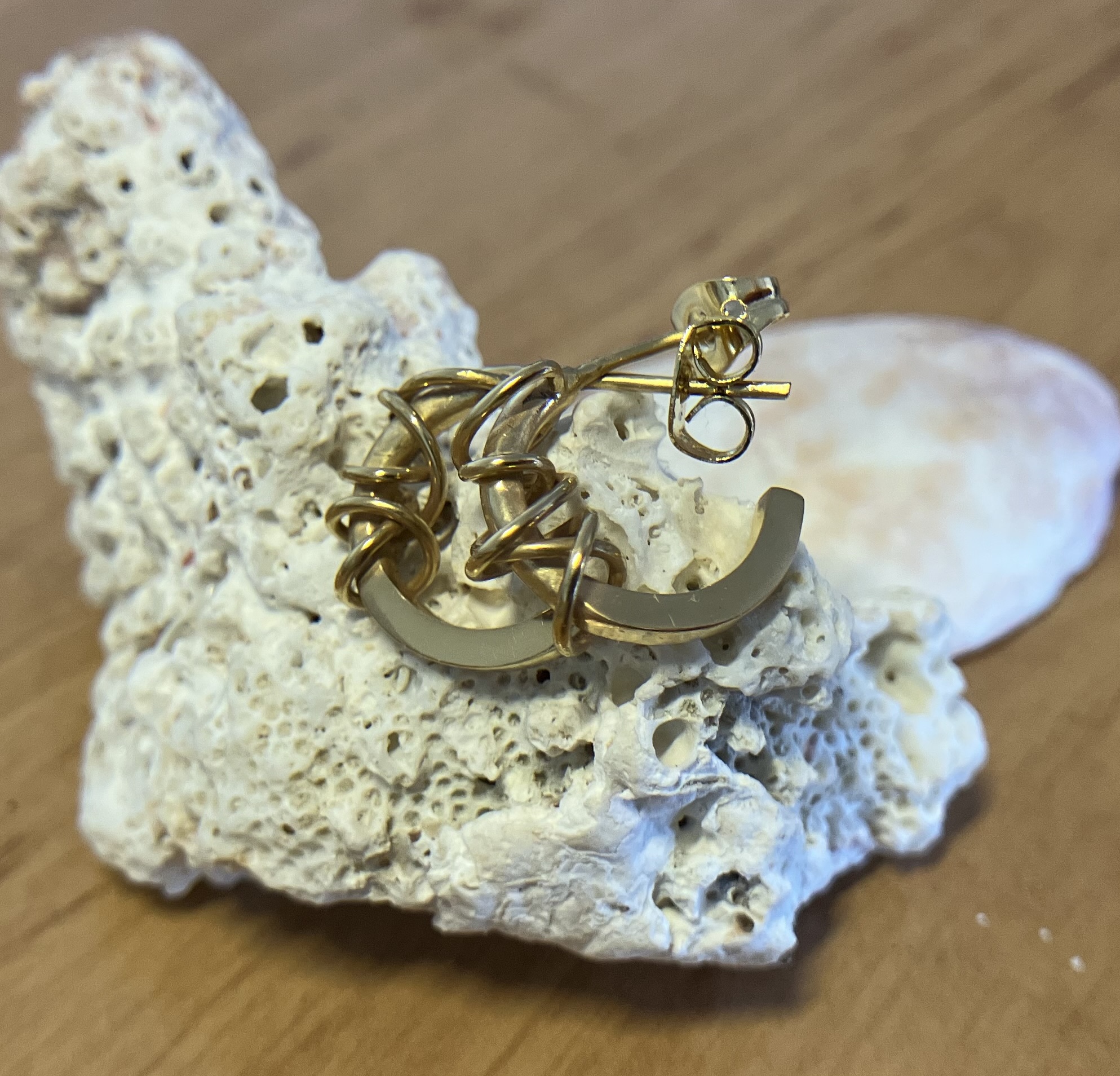 Small golden hoop earrings with wire wrapping the ends